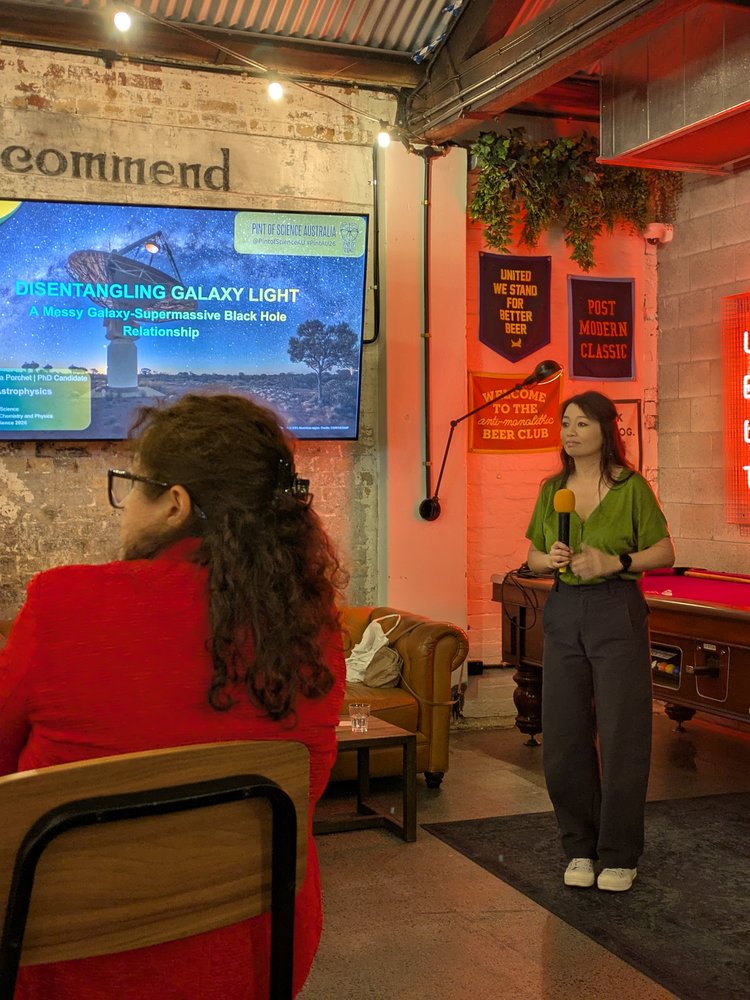 Vanessa Porchet presenting on galaxy light and supermassive black holes at Pint of Science